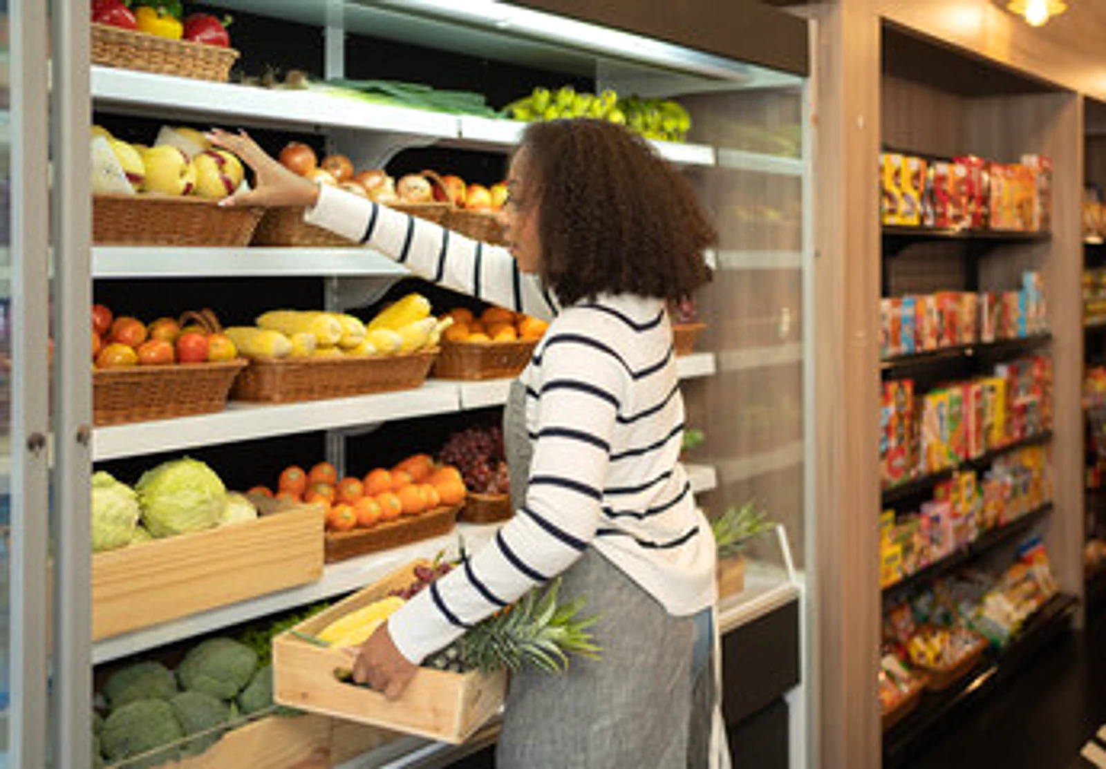 Staff arranging fresh fruit and vegetables in the produce aisle